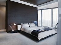 frühstückstablett auf doppelbett vor schwarz gefliestem raumteiler ... - Schlafzimmer Mit Raumteiler frühstückstablett auf doppelbett vor schwarz gefliestem raumteiler ... - Schlafzimmer Mit Raumteiler