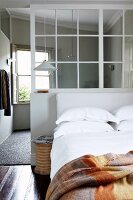 Gemütliches Doppelbett an Trennwand mit Innenfenster; im Hintergrund