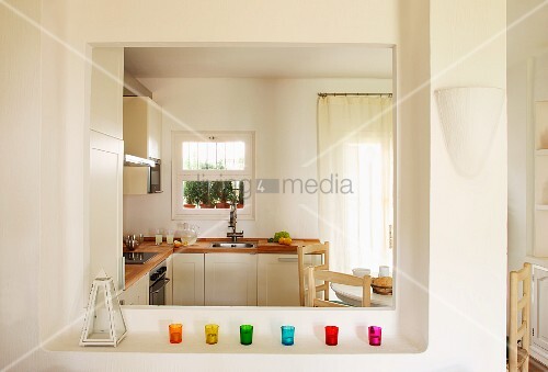 bunte windlichtgläser auf ablage vor durchreiche und blick in eine ... - Durchreiche Kuche Wohnzimmer Modern bunte windlichtgläser auf ablage vor durchreiche und blick in eine ... - Durchreiche Kuche Wohnzimmer Modern