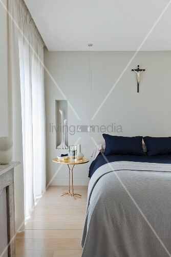 Doppelbett mit hellgrauer decke, krähenfuss tisch (traccia ...