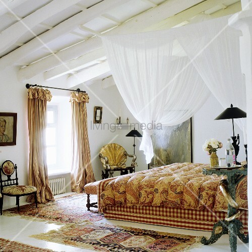 A White Canopy Hanging Above A Bed From A Wood Beam Ceiling