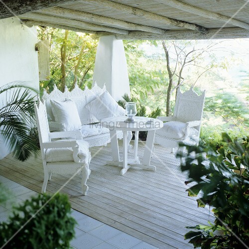 Weisse elegante Terrassenmöbel im spanischen Stil auf Holzterrasse