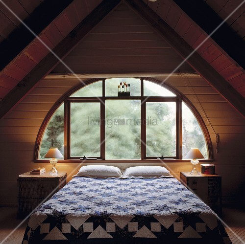 Ein loft schlafzimmer mit einem halbkreisförmigen fenster und ...