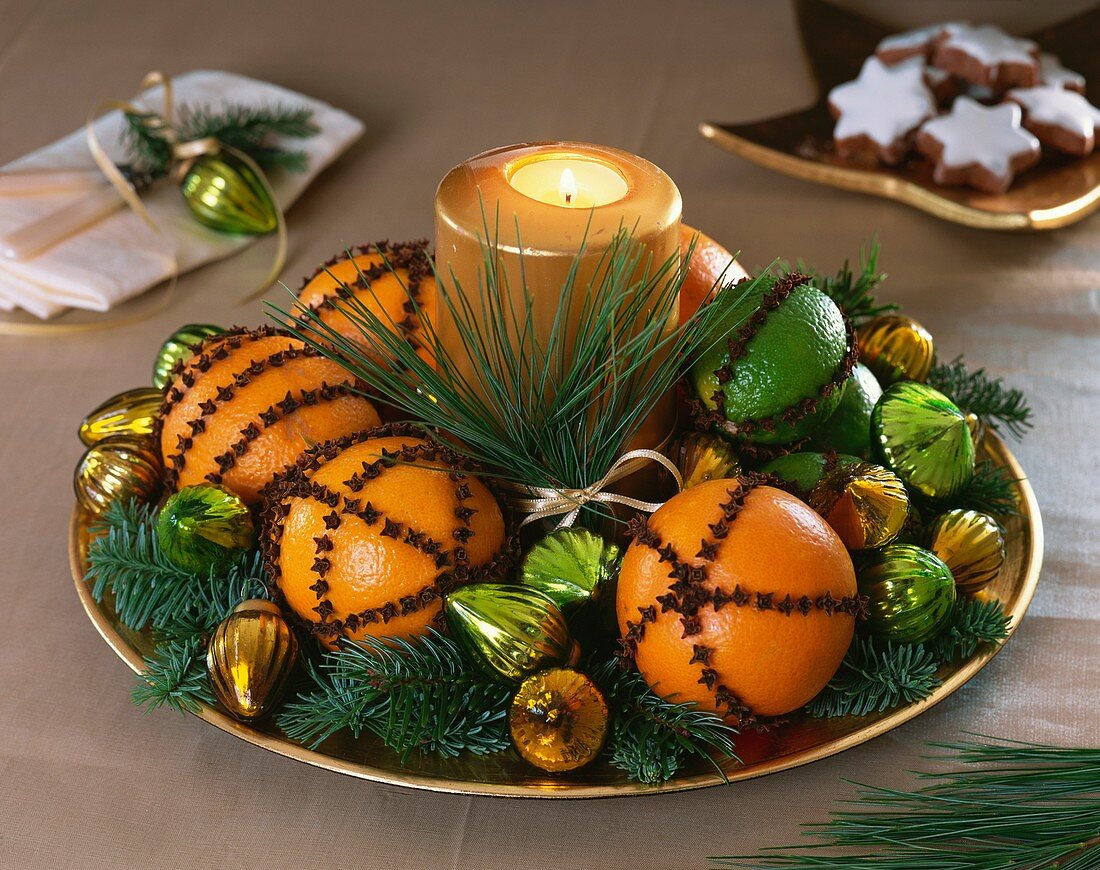 Oranges and limes studded with cloves, fir sprigs & candle