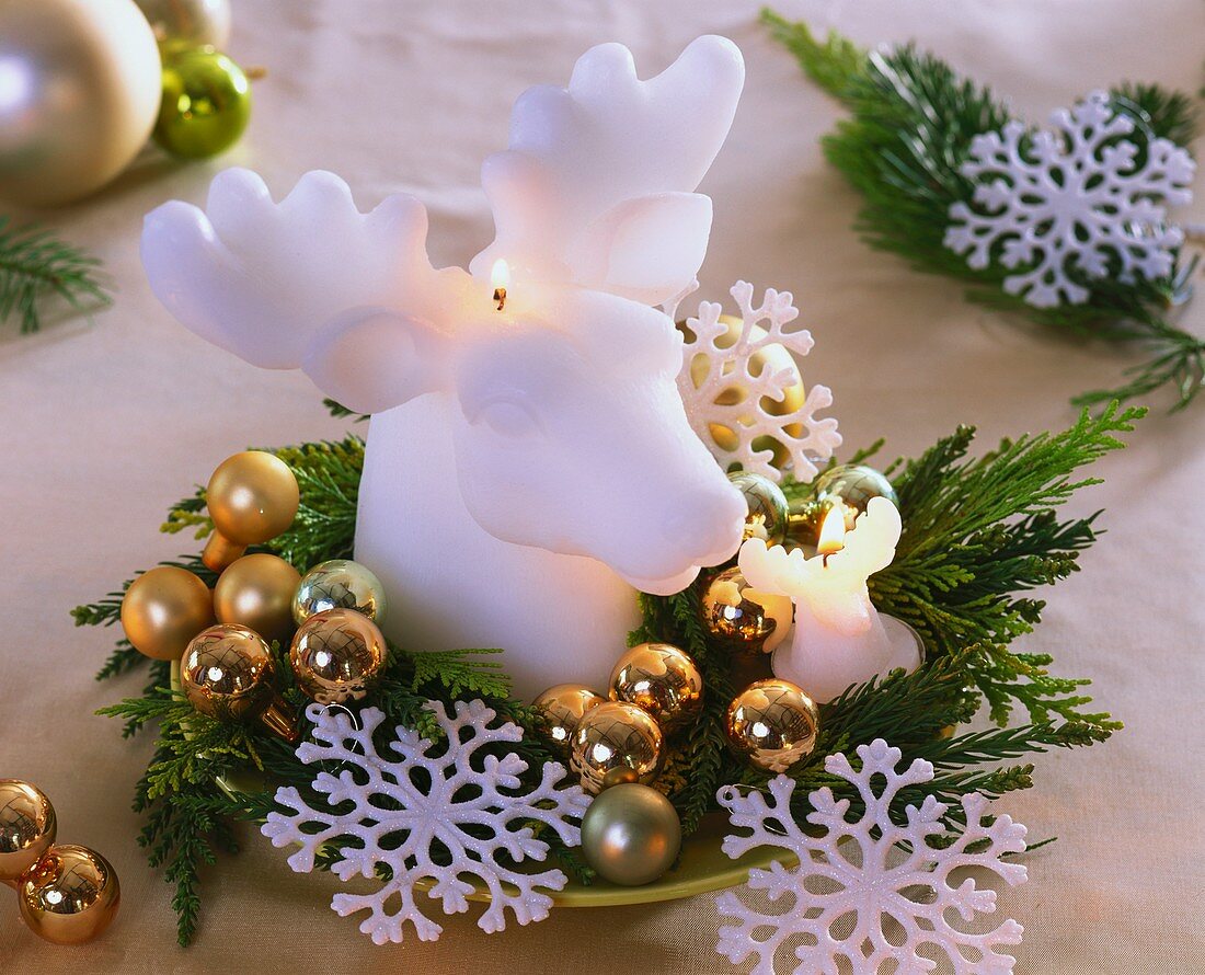 Candle in shape of elk's head with greenery, stars & baubles