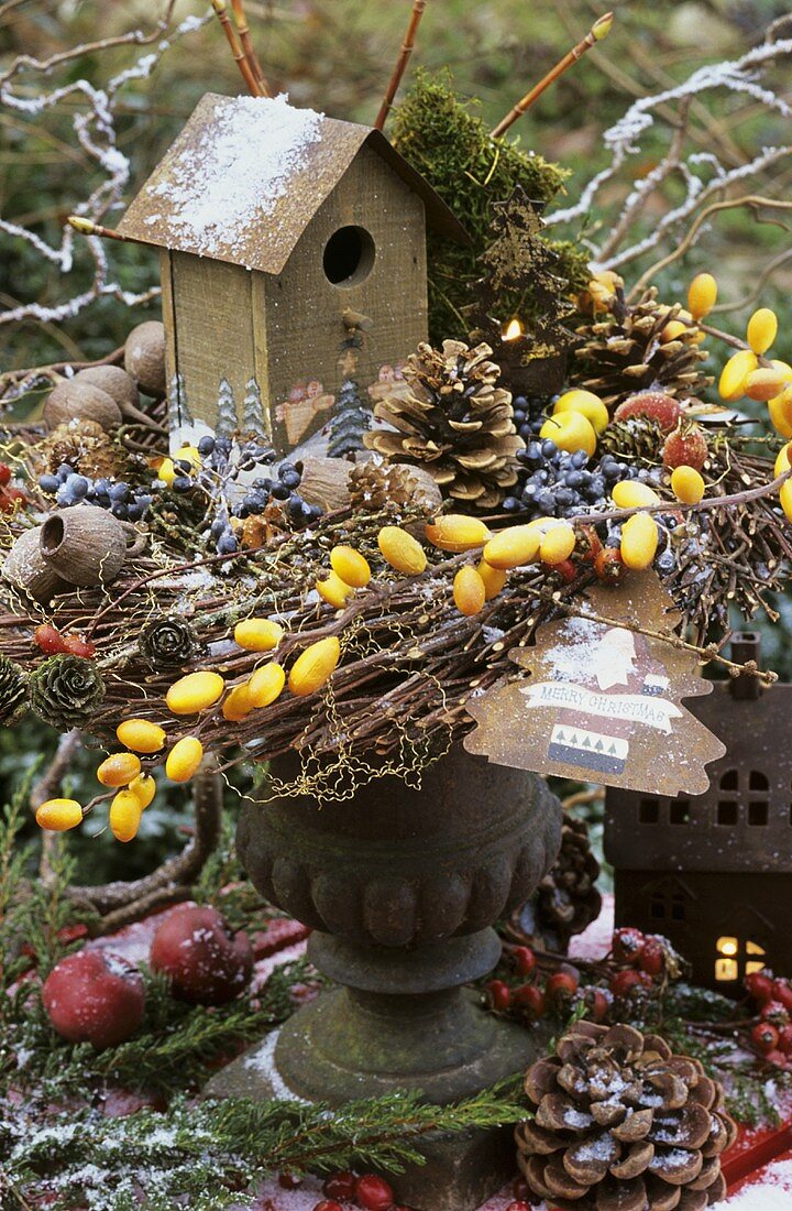 A bird house in a winter arrangement