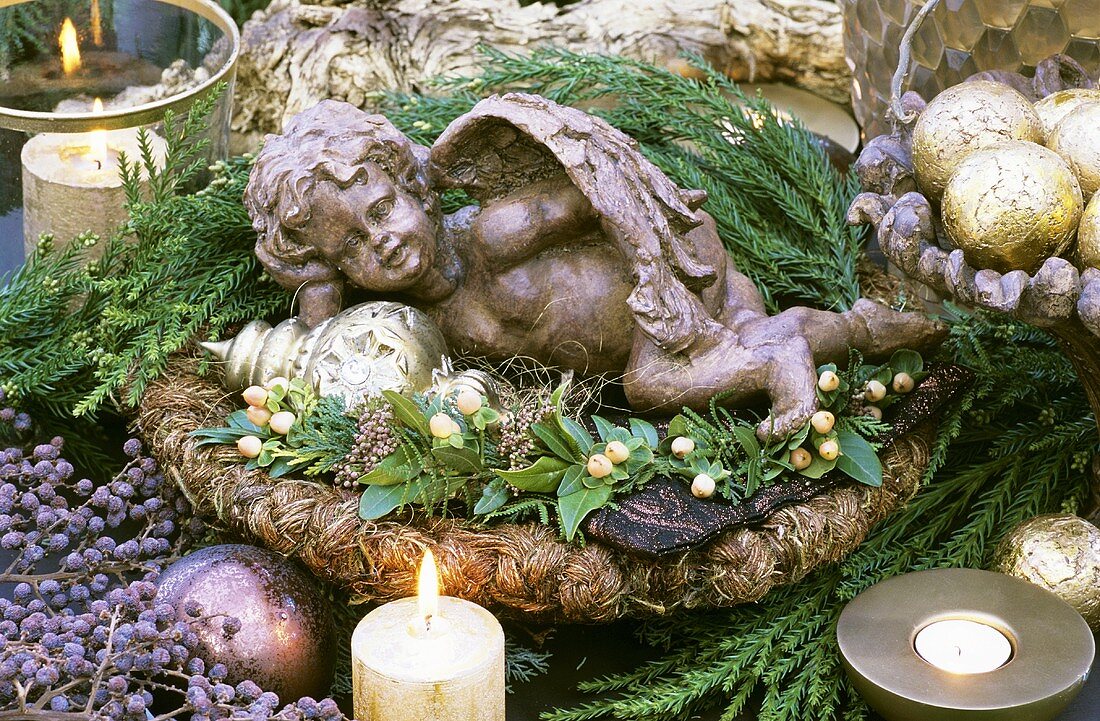 A little angel lying in a winter arrangement
