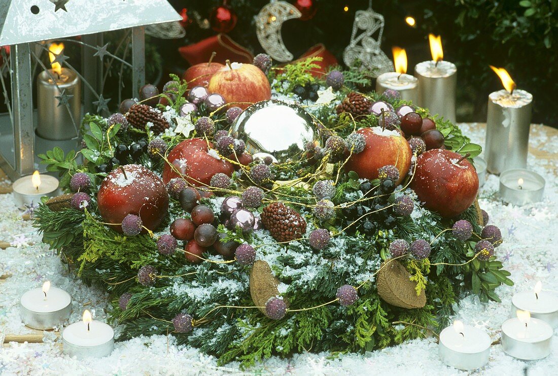 Wreath of fruit, nuts & conifer branches around a silver ball