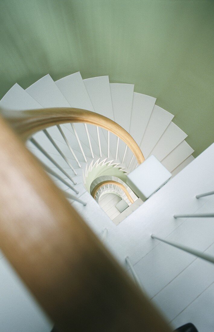 Blick hinunter einer Wendeltreppe mit Auge und Holzhandlauf