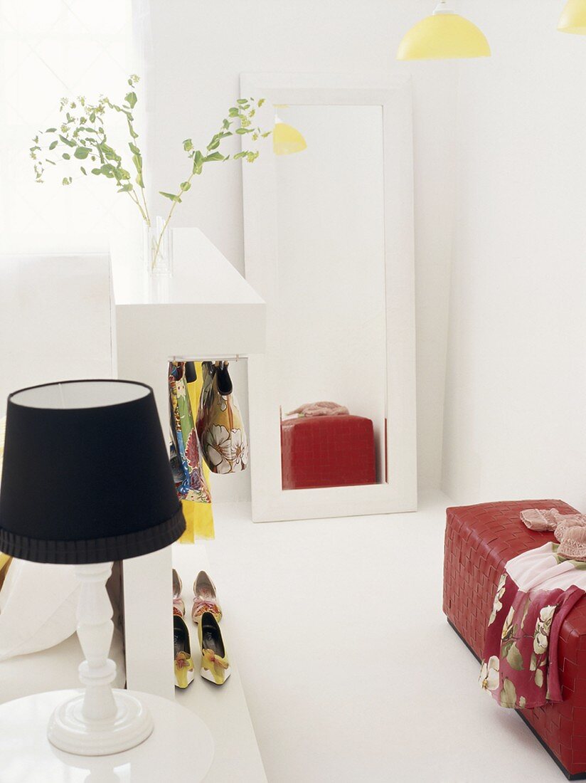 Feminines Ankleidezimmer mit roter Ledersitzbank und an der Wand angelehnter Spiegel