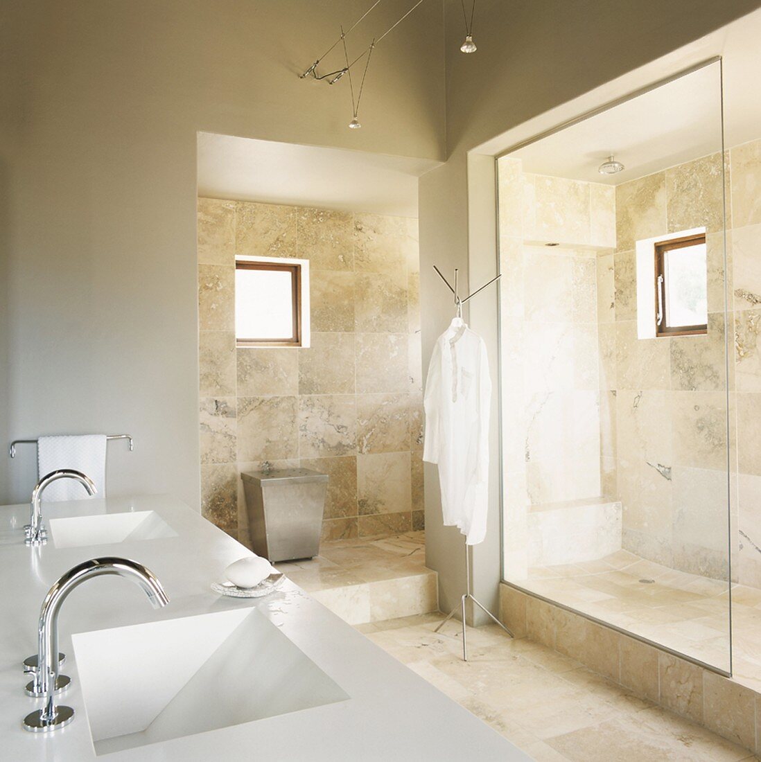 Designerbad in Natursteinoptik mit Nasszelle und Doppelwaschbecken sowie abgetrennter WC-Bereich