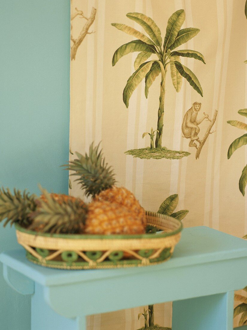 Ananas im Körbchen auf einem Tischchen