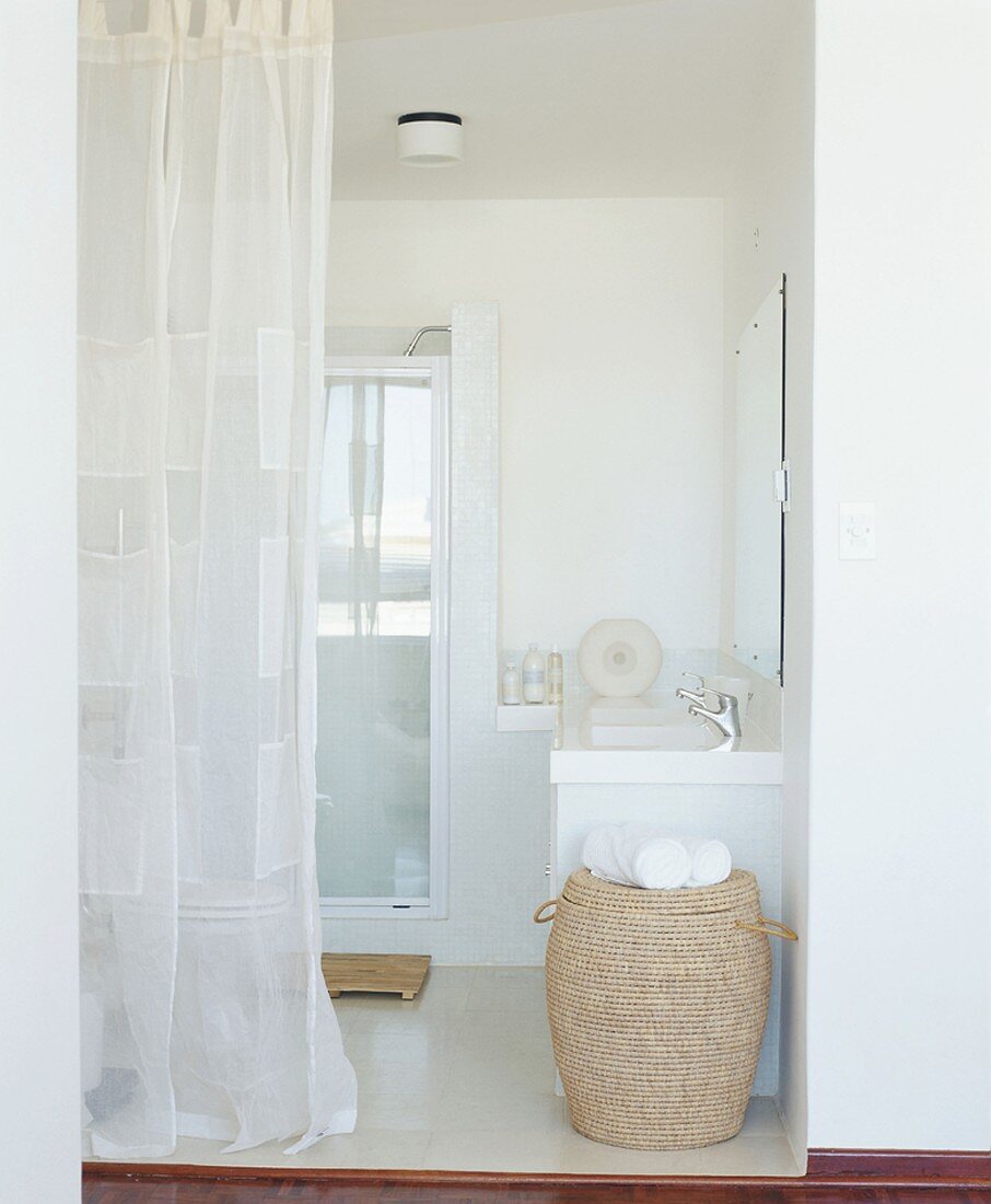 Blick in ein durch einen weißen Vorhang abgetrenntes Badezimmer