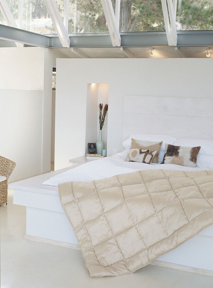 Doppelbett auf Podest unter verglaster Decke mit Stahl-Glaskonstruktion