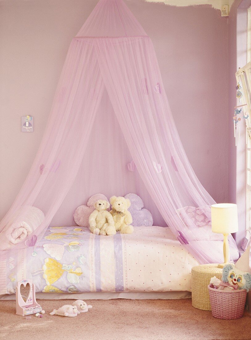Ein rosa Kinderzimmer mit Baldachin über dem Bett