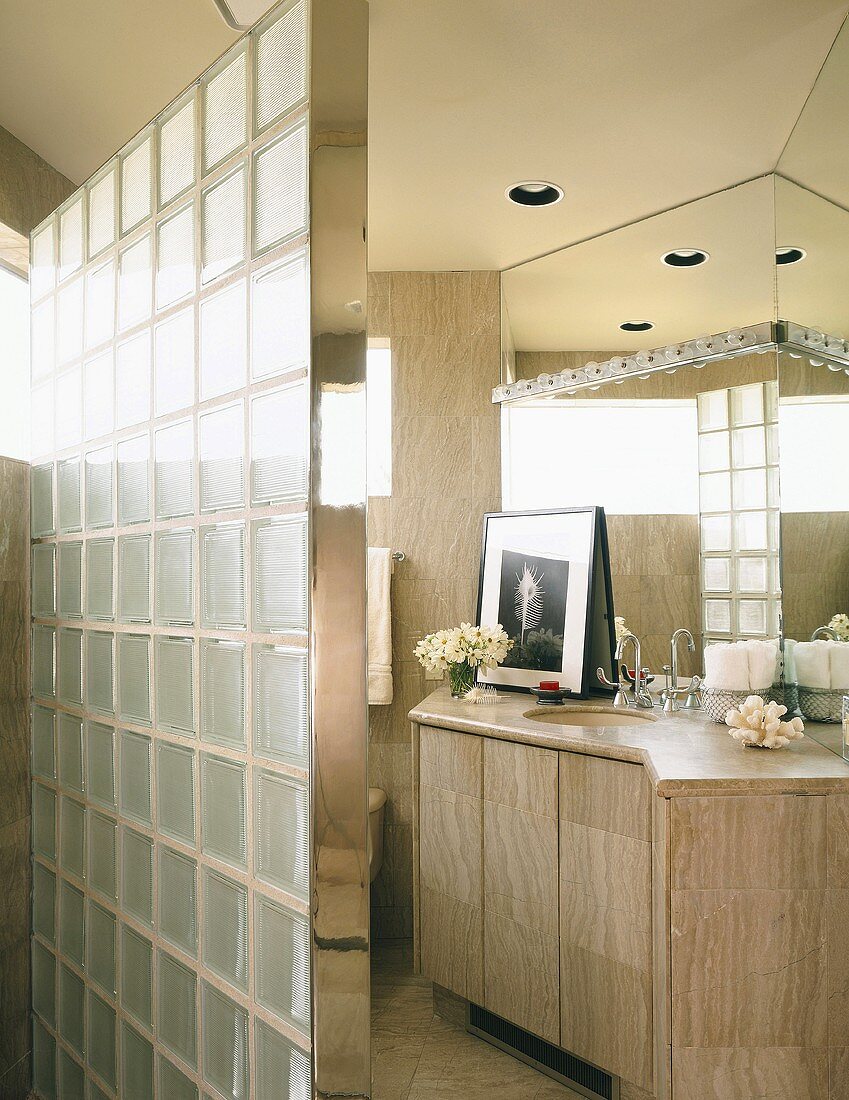 Badezimmer mit Steinfliesen und mit einer Trennwand aus Glasbausteinen