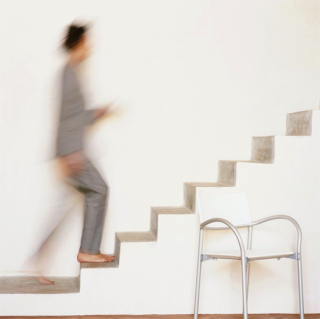 Frau geht auf einer freischwingenden Treppe nach oben