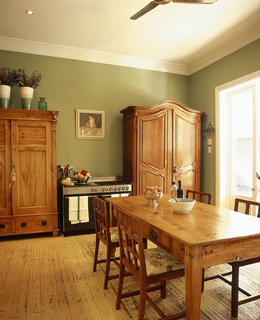 Gasherd zwischen zwei Holzschränken in einer rustikalen Küche mit grünen Wänden