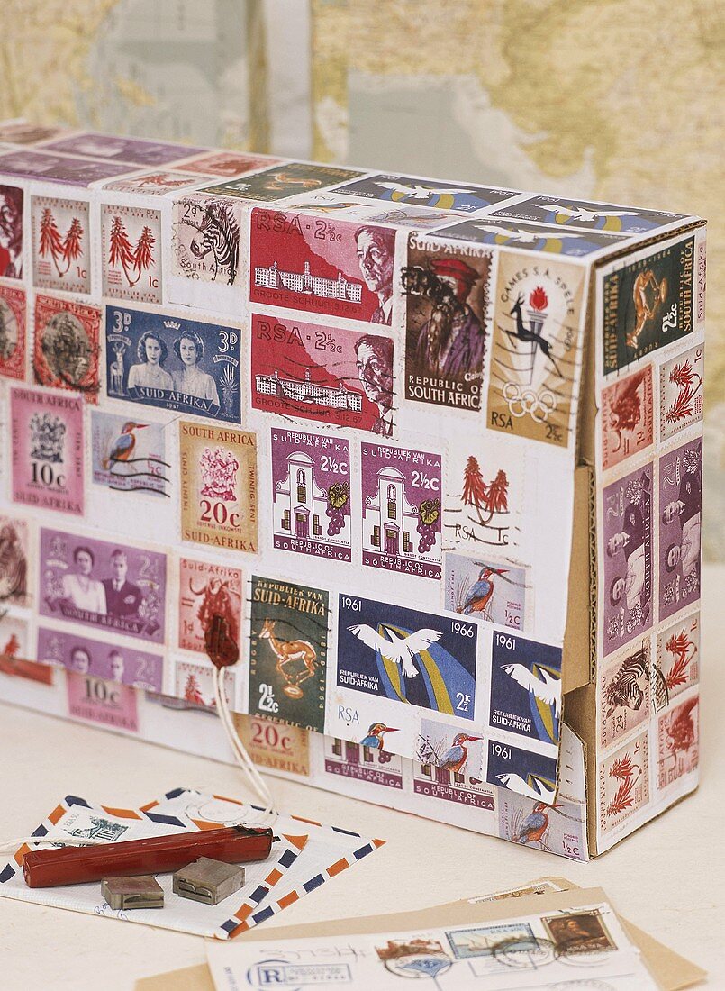 Cardboard box covered in postage stamps, letters, sealing wax & seal