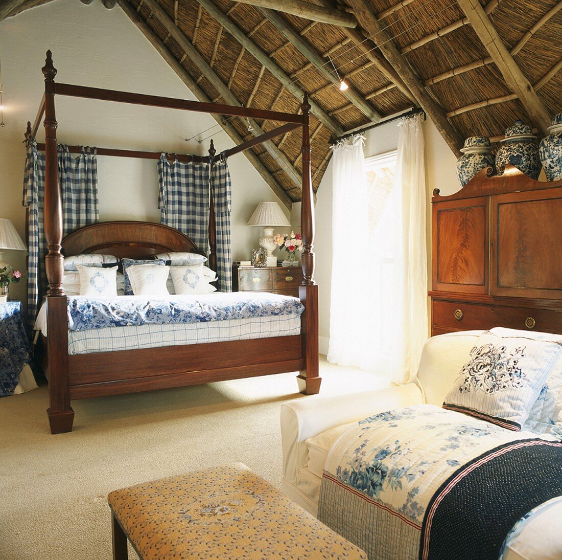 Antikes Himmelbett in einem Schlafzimmer mit rustikaler Deckenkonstruktion