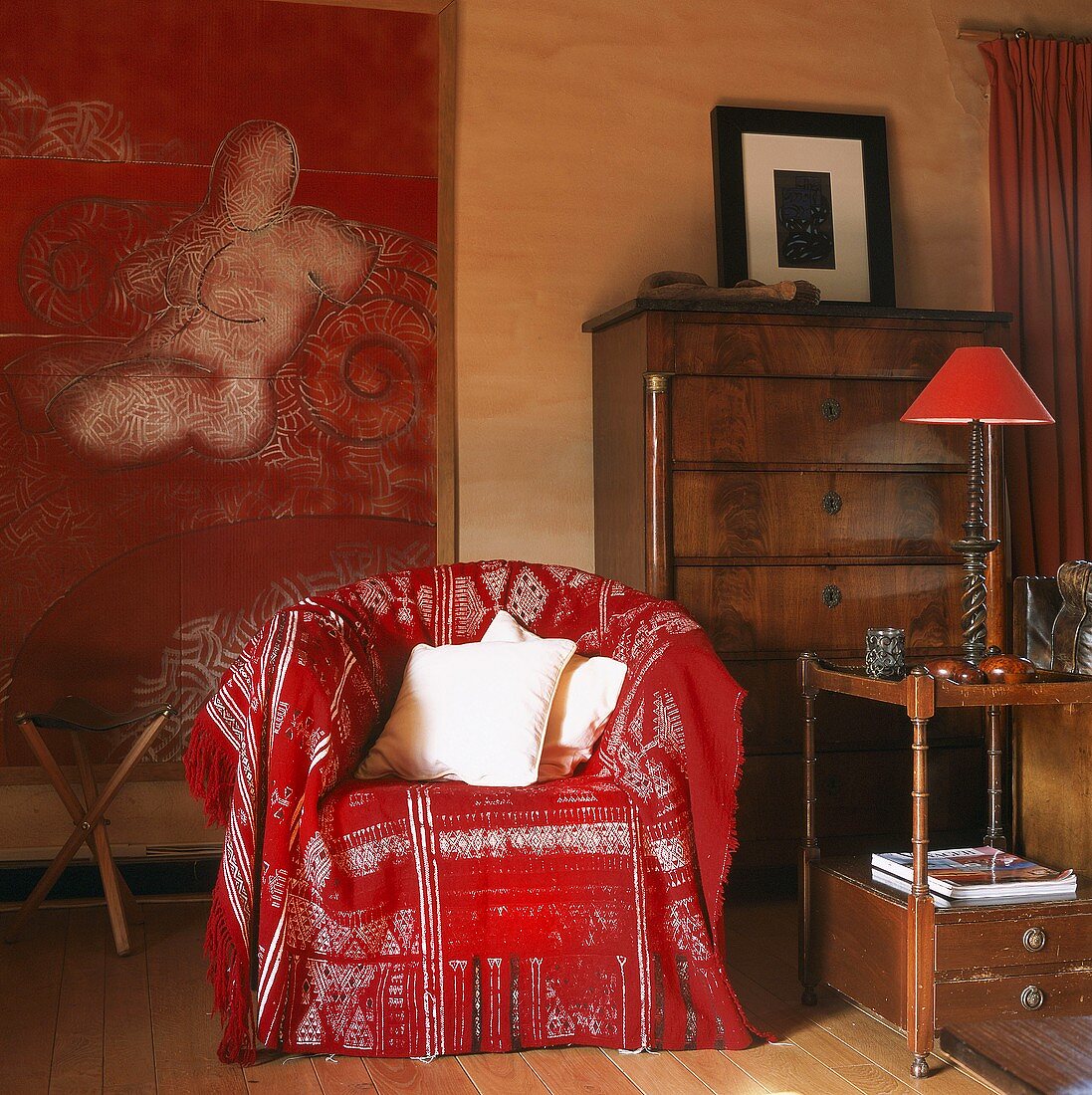 Sessel mit roter Decke vor zeitgenössisches Gemälde