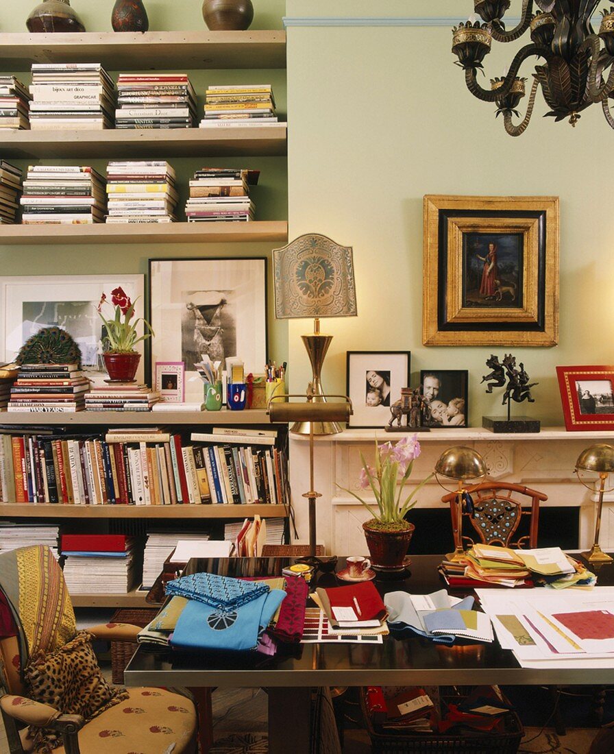 Ein vollgestelltes Arbeitszimmer mit vielen Büchern und Familienfotos