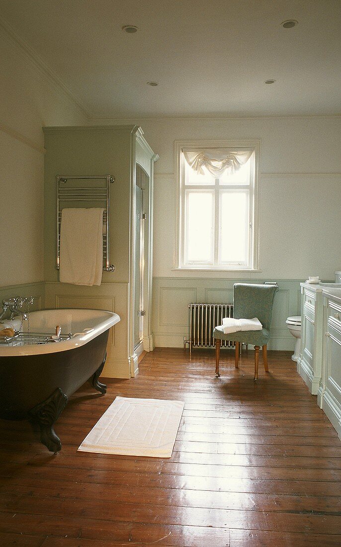 Freistehende Badewanne im mint-grünen Badezimmer mit Holzdielenboden
