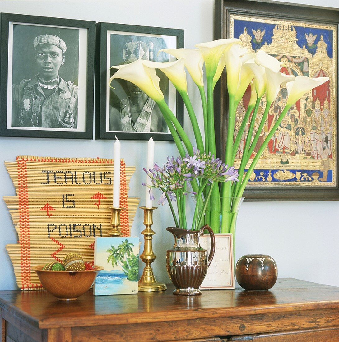Calla lilies and agapanthus in vases on console table