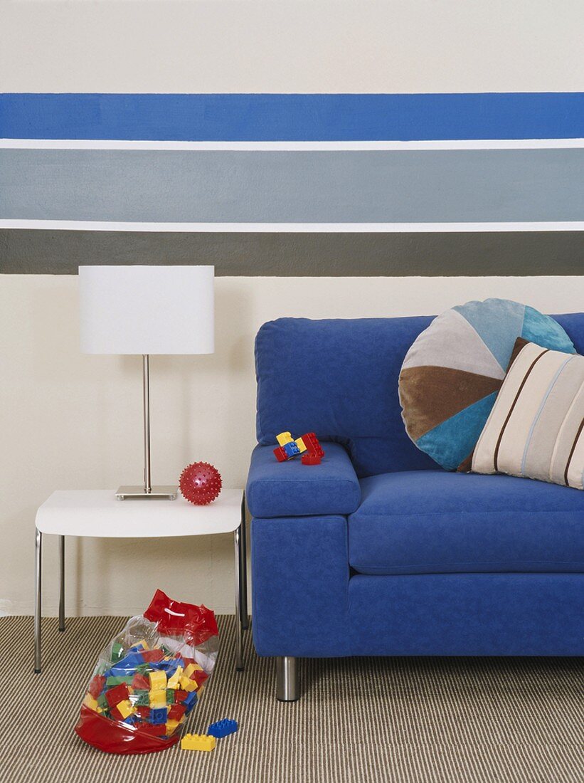 Blaue Couch mit Tisch und Tischlampe