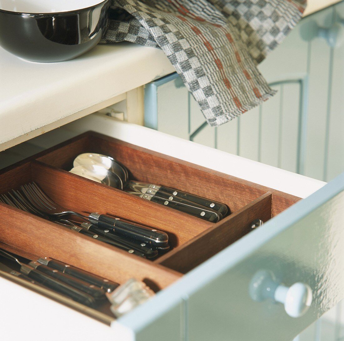 Open cutlery drawer in kitchen