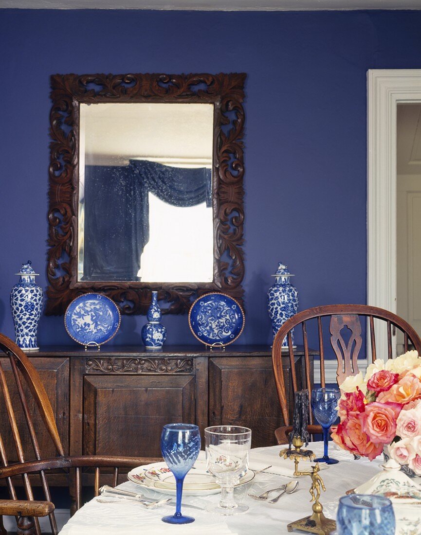 Festively set table in blue dining room with collection of Chinese porcelain and antique furniture