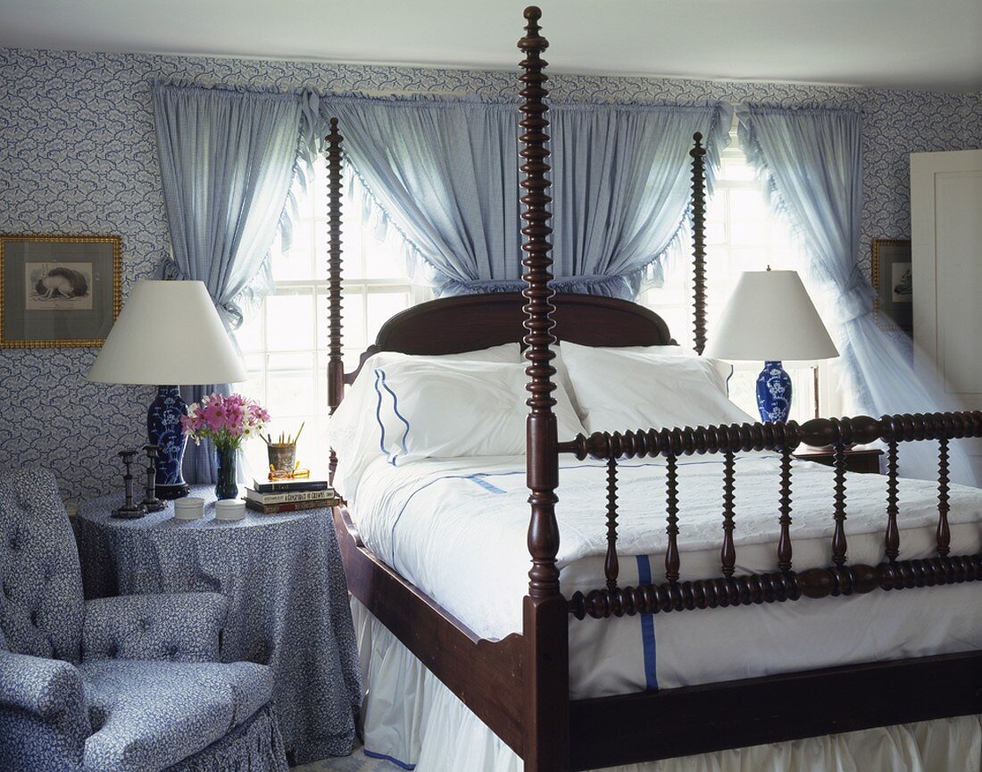 Kunstvoll gedrechselte Bettpfosten eines Doppelbettes in einem blau-weissen Schlafzimmer