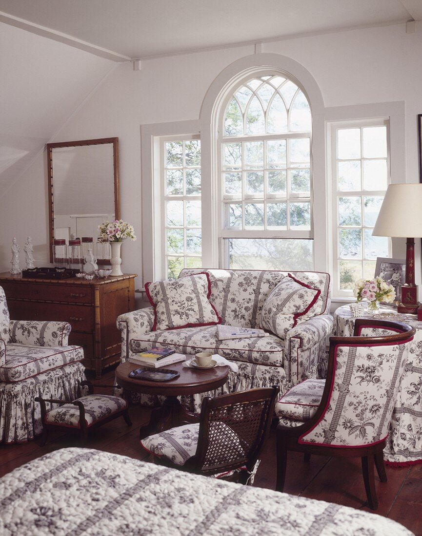 Large lattice window and furniture with matching upholstery in traditional living room