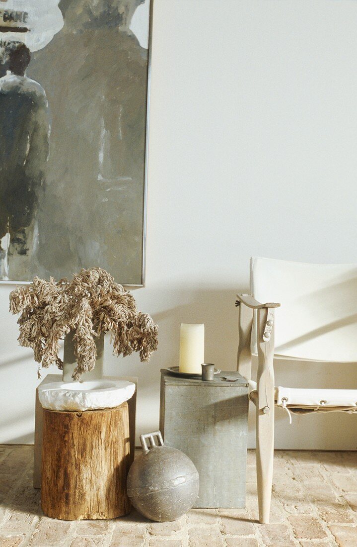 Einfacher Holzstamm als Tischchen vor modernem Gemälde; daneben ein Regiestuhl