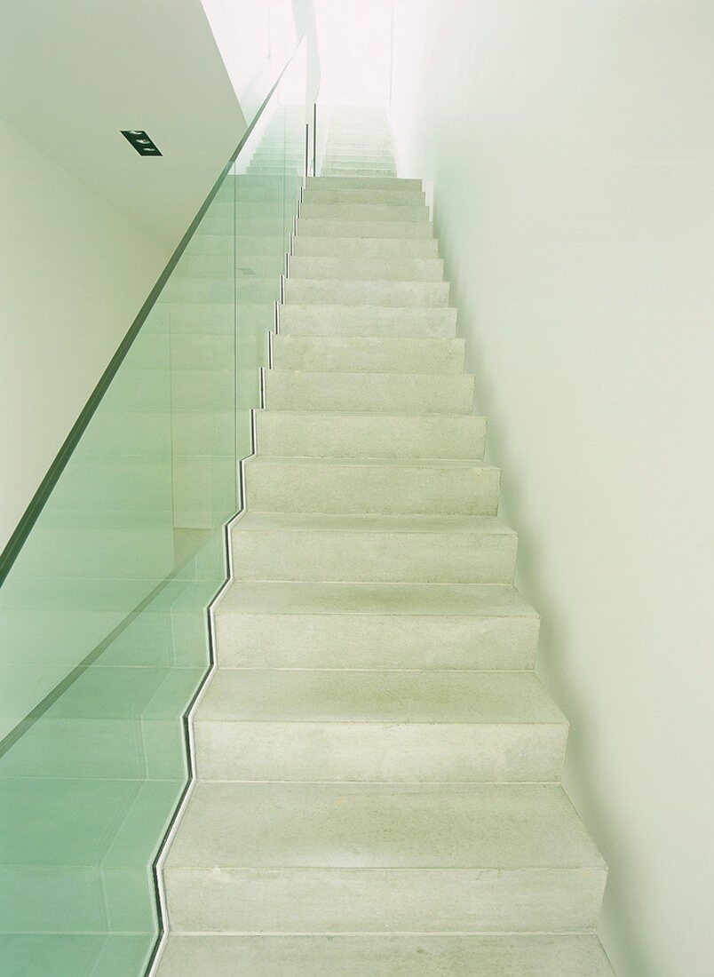 Treppenaufgang mit Betonstufen und einem Glasgeländer
