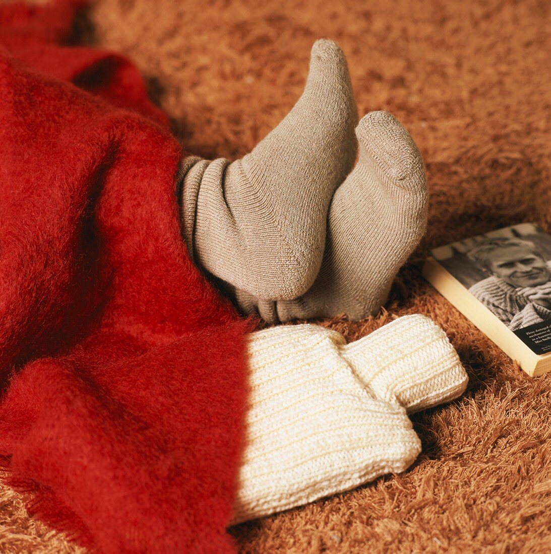 Feet in socks and hot water bottle peeping out from under blanket