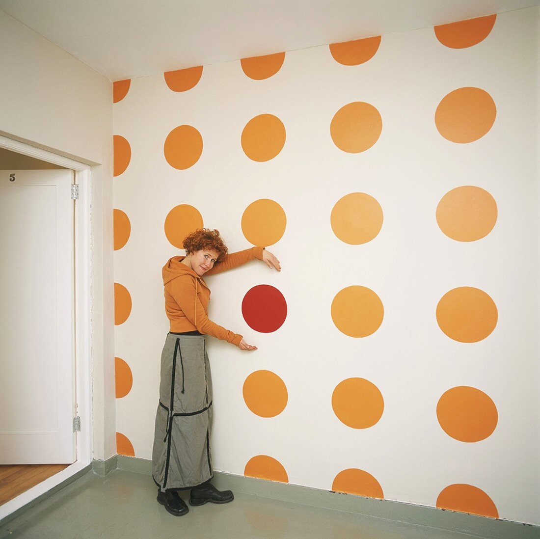 Woman standing in front of polka-dot wallpaper