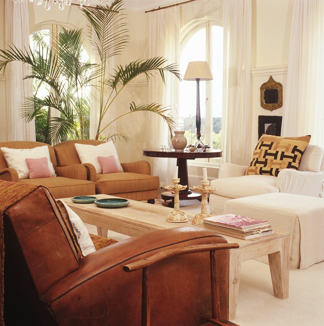 Lichtdurchflutetes Wohnzimmer mit komfortablen Sesseln und rustikalem Couchtisch
