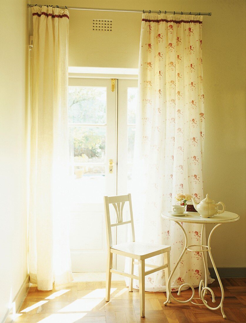 Romantische Sitzecke mit kleinem Kaffeetisch und Holzstuhl in Weiß
