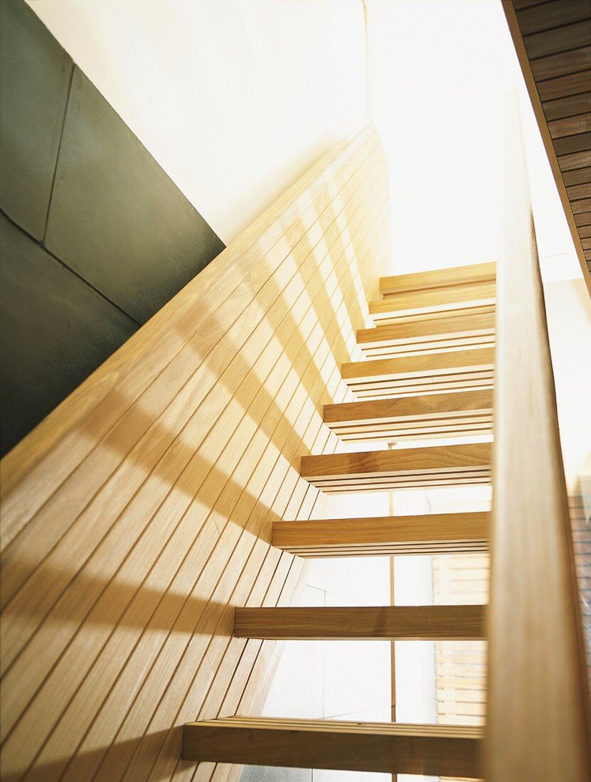 Treppe aus hellem Holz mit vertäfelten Handläufen