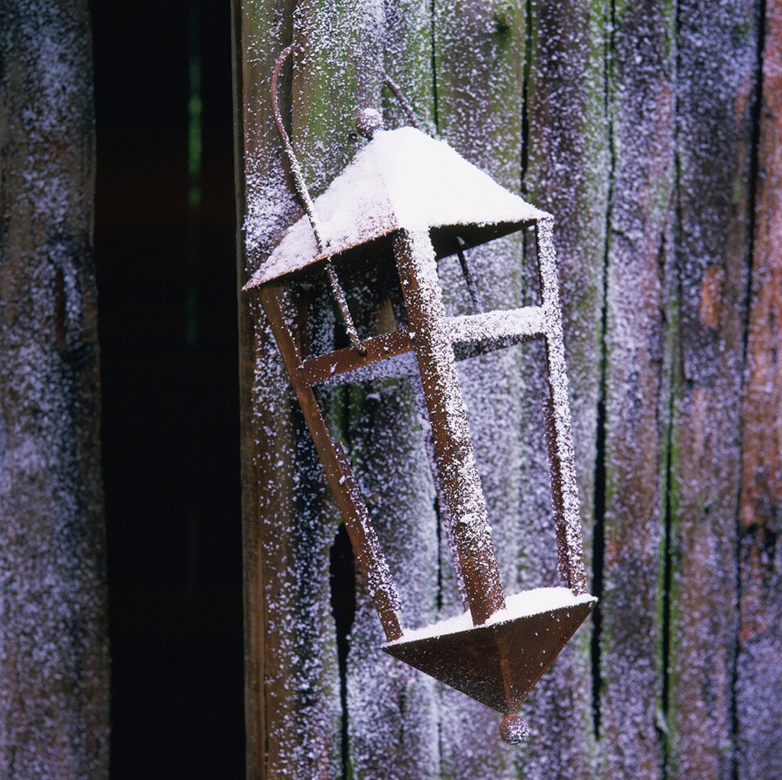 Lantern hanging on wooden wall