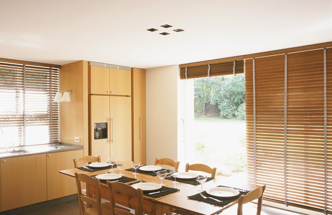 Gedeckter Esstisch in der Küche mit breiten Panoramafenstern
