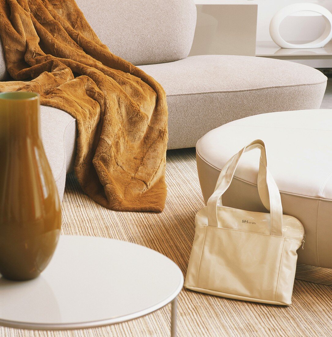Detail einer modernen Sitzecke mit einer Handtasche und einem Beistelltisch im Vordergrund