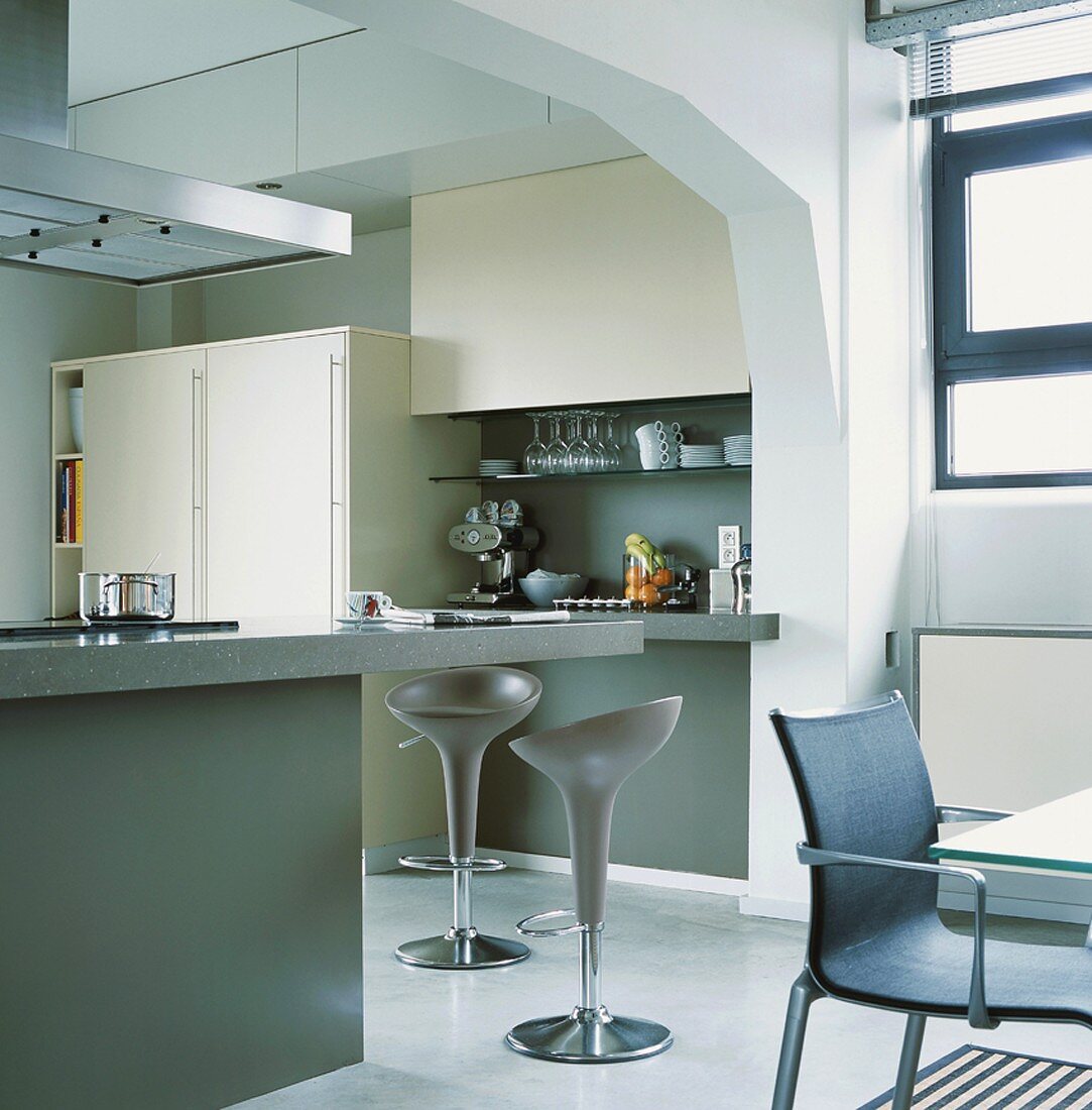 Die große Kücheninsel der modernen Küche bietet auch einen Thekenabschnitt mit Sitzmöglichkeiten