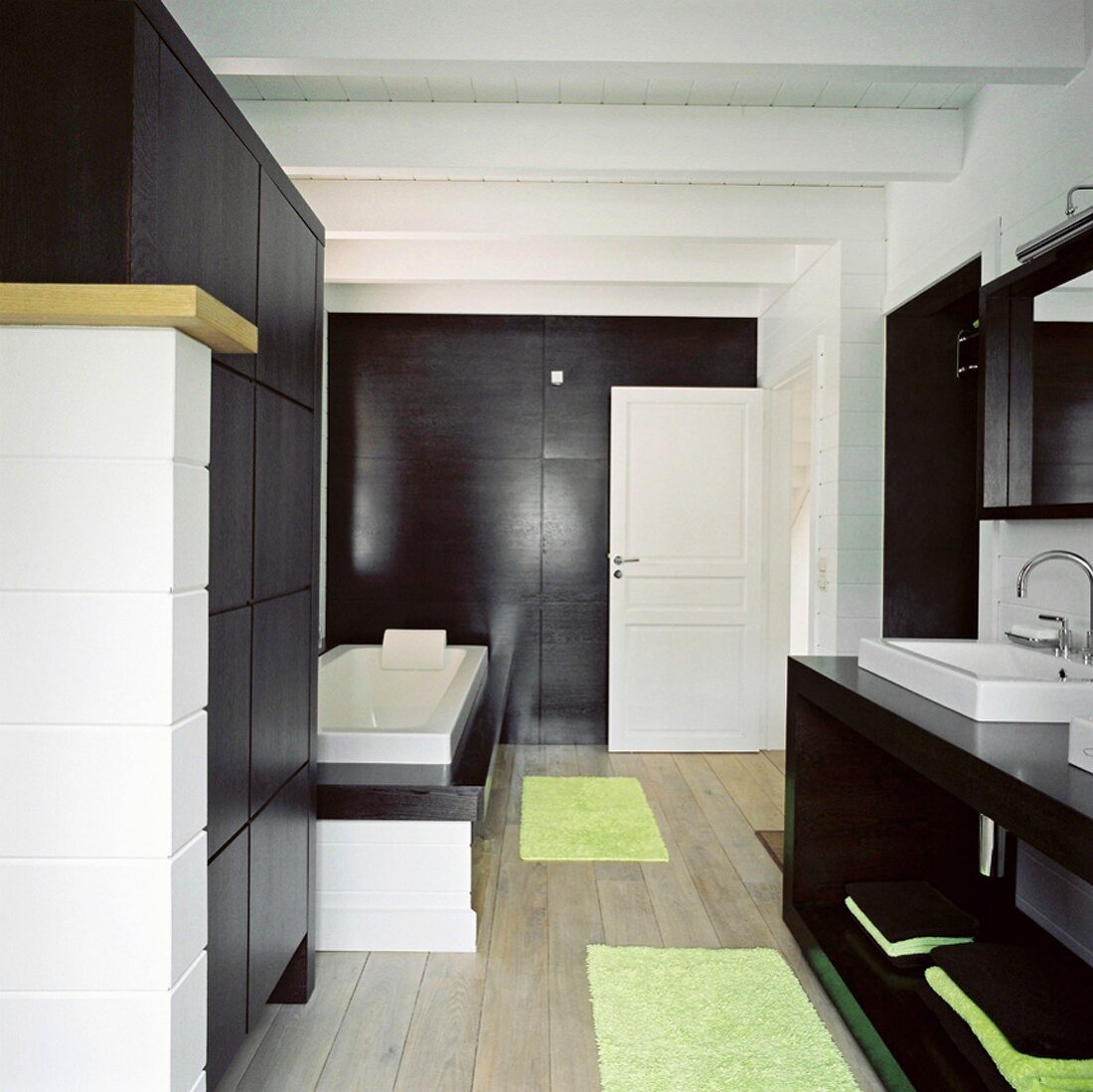 Ein puristisches Designerbadezimmer mit dunklen Holzoberflächen