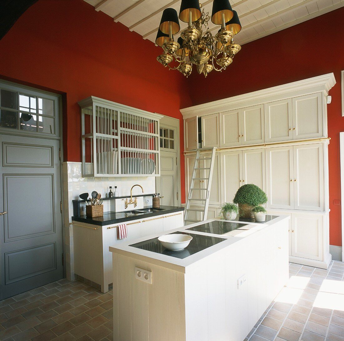Die Küche mit Steinboden und roten Wänden versprüht modern-elegantes Landhausflair