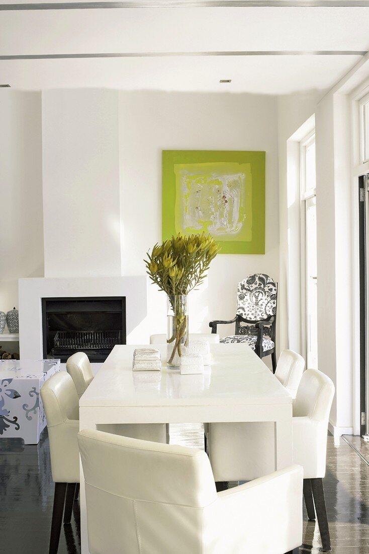 weiße Lederstühle an einem minimalistischen Esstisch