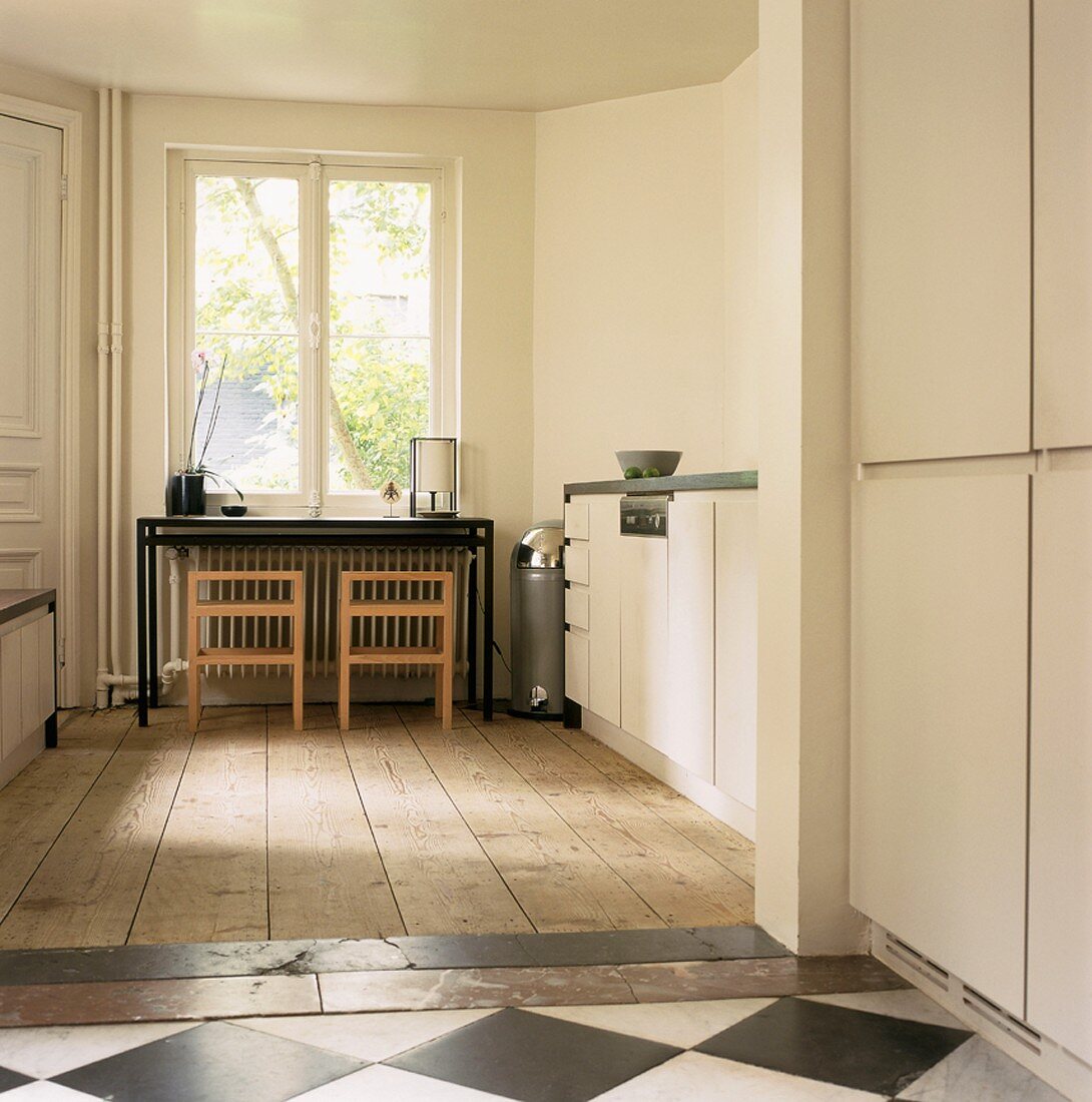 Der alte Holz- und Fließenfußboden verleiht der puristischen Designerküche einen besonderen Charme