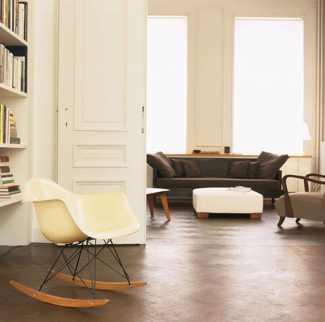 Die Schaukelstuhlversion des Plastic Armchair von Eames im eleganten Wohnzimmer mit Parkettfußboden und geöffneter Flügeltür