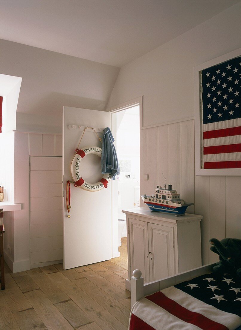 US-Flaggendeko in einem klassischen Schlafzimmer mit holzvertäfelter Wand und antiker Kommode